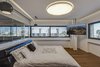 In the master bedroom, warm hardwood flooring and backlit perimeter lighting make the space bright and inviting. Panoramic windows overlook the urban cityscape, fostering a feeling of both openness and privacy. Photo 5 of Rishon Le Zion 3 modern home