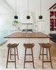 In the mostly-white kitchen, black Topan pendants by Verner Panton pop. The butcher block counters are an unusual height, so Lee designed custom-made stools to fit. Photo 3 of Color Splash modern home