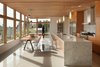 The ceiling on the main level of the home was built to reflect the same clear-stained cedar on the exterior. The mini pendants above the kitchen’s waterfall island—which is made of Carrara marble—are by Minka Lavery. Photo 2 of Cedar Douglas Residence modern home
