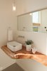 The home’s powder room features a countertop made of Douglas fir in a clear stain. It supports a ceramic vessel sink by Kraus below a chrome faucet in Danze’s “Parma Collection.” Photo 7 of Cedar Douglas Residence modern home