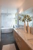 Modern home with Bath Room, Marble Counter, Undermount Sink, Freestanding Tub, Soaking Tub, Wall Lighting, Marble Wall, Open Shower, and Recessed Lighting. Edgewood cabinets adjoin countertops made from Carrara marble in the master bathroom. A Wyndham Collection bathtub sits under a chrome showerhead by Moen. Photo 8 of Cedar Douglas Residence