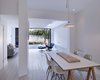 The ground floor of the home is both the clients' and architects’ favorite part of the home. The opened living room fulfills the owners’ wish for a private and quiet sanctuary connected to the rear garden yet removed from the noise of the front street. A key design feature was the widened rear opening, with floor to ceiling aluminum-framed Comar glass doors. Photo of A Compact, Light-Filled Victorian Renovation in England modern home