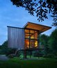 Modern home with Exterior, Cabin Building Type, Glass Siding Material, and Metal Siding Material. At just 350 square feet, this remote cabin with a view for the Sol Duc River sits on stilts to protect it from flooding and the dampness of the northwestern rainforest. Its shutters can be operated manually by custom steel rods. Photo of Olson Kundig Houses