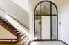 The main hallway and corridor leading to the apartment was kept all-original; the entrance appears just as it did 100 years ago. The interior offers a warm and modern respite, while respecting the colorful history of the schoolhouse. Photo 7 of The Schoolhouse modern home