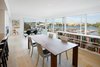 A Bensen Radius dining table and Hudson chairs by Emeco stand between the kitchen and the living room. Photo 3 of Portage Bay Bungalow modern home