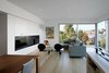 “The primary architectural strategy was to connect the exterior entry, primary interior living spaces, and exterior patio as a continuous spatial experience,” Hutchison says. Fleetwood Windows & Doors supplied the sliding pane to the outdoors. A crescent sectional by Camerich sits across from a custom steel-plate fireplace designed by Hutchison. Photo 4 of Portage Bay Bungalow modern home
