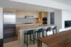 Broom stacking chairs by Philippe Starck face Caesarstone countertops in the kitchen. A Liebherr refrigerator and Wolf stovetop are on the opposing wall, alongside bleached white oak casework that was custom made by Hutchison and interior designer Carla Allbee. Photo 5 of Portage Bay Bungalow modern home