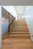 Custom bleached-white oak flooring covers the floors, including on the staircase to the property’s second floor. Juno five-inch LED recessed wall lighting illuminates the steps at night. Photo 6 of Portage Bay Bungalow modern home