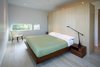 A Risom Lounge Chair by Knoll faces a BoConcept bed. A Tizio desk lamp from Design Within Reach acts as additional lighting. Custom casework by Hutchison and Allbee matches the kitchen’s finished look. Photo 7 of Portage Bay Bungalow modern home