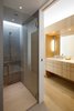A Hansgrohe Raindance shower head is mounted behind the glass in the master bathroom. A Kohler Ladina undermount sink sits under the vanity mirror. Photo 8 of Portage Bay Bungalow modern home