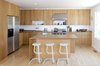 Modern home with Kitchen, Undermount Sink, Range Hood, Range, Wood Cabinet, Light Hardwood Floor, Refrigerator, Dishwasher, Recessed Lighting, and Wood Counter. Movable and space-saving design elements define this creative family home in the Mission District. The kitchen was given an economical revamp by adding new drawer and door fronts to the existing cabinet boxes. Countertops were replaced with custom fabricated white oak butcher block surfaces, and a complementary white oak kitchen island was installed. A Wolf range, Vent-a-Hood hood, Franke stainless steel sink, and Bosch dishwasher complete the space. Photo 8 of KS Mission