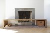 Modern home with Living Room, Wood Burning Fireplace, Standard Layout Fireplace, Light Hardwood Floor, and Bench. Movable and space-saving design elements define this creative family home in San Francisco’s Mission District. A midcentury home was transformed, and through the renovation, the molding at the fireplace was taken down, as was the cast plaster mantle. The sleek, new, metal fireplace design features a white oak custom bench made by Zack, accented by a vintage carnation milk crate from his mother’s childhood. Photo 9 of KS Mission