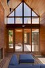 A Douglas fir ceiling in the screened porch and red bricks are accented by blue Arizona modular outdoor seating by Barlow Tyrie. Photo of A Traditional Facade Hides A Light-Filled Modern Delaware Renovation modern home