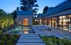 Outdoor lounge chairs by Richard Schultz sit on brick floors. The pool’s changing pavilion features a full bathroom. Photo of A Traditional Facade Hides A Light-Filled Modern Delaware Renovation modern home
