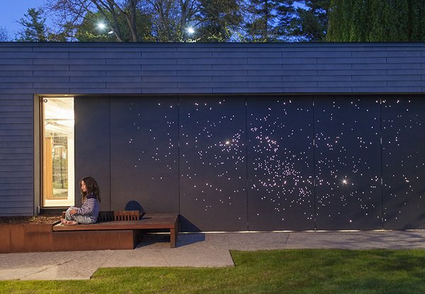 Architect Janna Levitt laser-cut an astral pattern into the garage door of this renovated Toronto home, installing LED lights behind the fiber-cement surface to complete her depiction of the constellations Sagittarius and Scorpio.