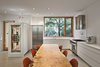 A 13-foot long dining table comprised of silver maple from Urban Tree Salvage is colorfully framed by Saarinen Executive side chairs. Over in the kitchen, a Liebherr refrigerator matches a Wolf stove. Photo 2 of King West modern home