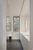 In the master bathroom, Dolomite marble was installed on the walls to complement Caesarstone countertops. Both contrast with the dark Montauk slate on the floor. Photo 8 of King West modern home