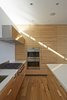 Modern home with Kitchen, Engineered Quartz Counter, Medium Hardwood Floor, Range, Glass Tile Backsplashe, Range Hood, Wall Oven, Recessed Lighting, and Undermount Sink. Sleek Wolf and Sub-Zero appliances, along with Caesarstone countertops, complete the kitchen. Photo 3 of Noe Residence