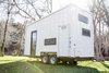 Rooftop solar panels and a rainwater filtration system minimize its dependence on the grid. Photo of A Tiny Trailer Home Harvests Solar Power and Rainwater to Save Energy modern home