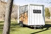 Living space is extended outdoors by a fold-down deck and fold-up awning, both of which fit economically within the same frame. Photo of A Tiny Trailer Home Harvests Solar Power and Rainwater to Save Energy modern home