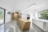 Modern home with Kitchen, Wood Counter, Concrete Floor, and Wood Cabinet. Bernier’s firm designed the built-in storage, seating area, and kitchen island to be intentionally abstract, directing attention to the forest outside. Cabinetmaker Pixel & Scie manufactured the furniture. Photo 4 of House of Lake Grenier