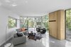 An unassuming hickory entertainment system, also designed by Bernier, contrasts with the living room’s polished concrete floors and white walls. Custom seating by Meubles Reno and fixtures by Axis Lighting further complement the space. Photo 5 of House of Lake Grenier modern home