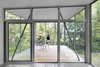 Large aluminum windows by Alumilex offer striking views while taking advantage of the sun’s orientation. In the summer, the leafy trees help shield the house from heat. During cooler months, sunlight filters through bare tree branches to flood the home with warmth and light. Photo 6 of House of Lake Grenier modern home
