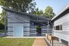 The three-bedroom home wraps around the atrium between the garage and main building. Since the garage faces the alley, this orientation opens up the front yard and garden. The big sliding doors off the atrium help the home connect with the community, supporting sidewalk interactions. "The idea was to draw the space back out to the neighborhood," he says, "and create different levels of security and privacy." Photo of Habitat for Humanity Home in Kansas Channels Midcentury California modern home
