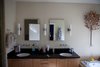 The existing master bathroom was “perfectly nice,” but uninspiring. Brigham and Archuleta salvaged as many of the original fixtures as possible to cut down on waste, choosing pieces that would blend effortlessly with the new design. The bath was re-set in a concrete base to give it new life. Photo of Warm Wood Modern Bathroom Renovation in San Francisco modern home