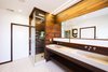 Modern home with Bath Room and Wall Mount Sink. The entire bathroom is based on a grid, informed by Brigham’s background in graphic design. The 4” redwood slats form the base measurement; the height of the sink, the bath, and all other features are built in multiples of four. Each piece was designed to either project from or recess back into the wall, continuing seamlessly into the next fixture. Everything from the medicine cabinet to the planters floats off the ground, opening the space. Photo of Warm Wood Modern Bathroom Renovation in San Francisco