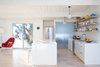 Modern home with Kitchen, Pendant Lighting, White Cabinet, Light Hardwood Floor, Refrigerator, Range, Drop In Sink, Dishwasher, and Range Hood. All the floors were redone in a light ash hardwood. The crisp interior paint is Benjamin Moore Super White. The kitchen cabinets are from Artistic Kitchens. A frosted glass door leads to the laundry room. Photo of Modern Master: Joseph Eichler