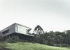 Modern home with Grass, Exterior, House Building Type, Concrete Siding Material, Glass Siding Material, and Flat RoofLine. Teeland Architects designed this on Australia’s Sunshine Coast in order to maximize views of the Pacific Ocean to the east as well as the surrounding forest to the north. Photo of Modern House Captures Panoramic Views in Australia modern home