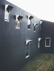 Modern home with Exterior, House Building Type, Concrete Siding Material, Flat RoofLine, and Glass Siding Material. The cement exterior walls were painted in a dark color to blend in with the forest. Aluminum window frames add some texture to the facade. Photo of Modern House Captures Panoramic Views in Australia