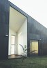 Modern home with Exterior, Concrete Siding Material, Glass Siding Material, Flat RoofLine, and House Building Type. The house uses solar panels and water tanks to function off the grid. Its waste water is recycled and used for irrigation. Photo of Modern House Captures Panoramic Views in Australia