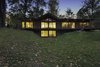 “The use of the structural insulated panels for the roof allowed us to keep the exposed post-and-beam look, which is a midcentury trademark, while making the house energy-efficient,” Schultz said. Douglas firm beams and soffits support a SIPS roof, which shades Andersen Windows & Doors. The deck, made of red meranti, overlooks a nearby pond. Photo of City Skyline modern home