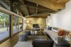 Modern home with Living Room, Chair, Ceiling Lighting, Sofa, Ottomans, Medium Hardwood Floor, and Standard Layout Fireplace. Stained white oak spreads across the living room under Douglas fir beams. At the far end of the room, a Jonathan Adler lamp stands next to an original limestone fireplace that was restored. Photo 2 of City Skyline