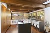 Custom cabinetry with a walnut veneer is across from Caesarstone countertops and a Basaltina tile backsplash by Stone Source. Photo 5 of City Skyline modern home