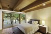 An Anthropologie rug adds color under a West Elm bed, which is sandwiched between Design Within Reach side tables. Caravan lamps show the detail in Cowtan & Tout wallpaper. Photo 7 of City Skyline modern home