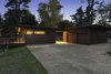 Stained western red cedar extends around the full exterior of the home. A pea gravel driveway stays in place with a steel edge. Photo 9 of City Skyline modern home