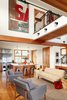 Far from the dark, cavernous barns of the Midwest, tall ceilings and an open floor plan creates an airy interior. Architect Bill Bickford and contractor Traditional Carpentry, Inc. collaborated on a unique sliding door to the upstairs master suite: a vintage billboard cut in half and put on a barn door track. The sitting area below features Raleigh Armchairs from Design Within Reach and a loveseat from Jayson Home. Photo of House of the Week: An Eco-Friendly Family Retreat Built with Reclaimed Materials modern home