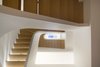 Modern home with Staircase and Wood Tread. The Piranesian view upwards through the central stair to the top floor skylight. Photo of White Oak