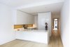 Modern home with Kitchen, Engineered Quartz Counter, White Cabinet, Light Hardwood Floor, Ceiling Lighting, and Undermount Sink. The kitchen has views to the historic main entrance and features lacquered cabinets and an integrated wooden niche custom-designed by the architects with GD Cucine. Matching Corian countertops and an integrated sink maintain a minimal aesthetic alongside appliances by Gaggenau and Miele. Photo 2 of White Oak