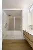 Modern home with Bath Room, Medium Hardwood Floor, Alcove Tub, Vessel Sink, Engineered Quartz Counter, Soaking Tub, Open Shower, Accent Lighting, and Ceramic Tile Wall. The master bedroom includes a luxurious ensuite bath with a white Thassos marble shower box and subtly-patterned Flores tiles by Mutina. The white oak continues in the vanity, with a Thassos top, vanity lighting by Aamsco, and all fixtures by Dornbracht. Photo 6 of White Oak