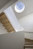 Modern home with Skylight Window Type, Staircase, and Wood Tread. The architects added a small circular skylight to serve as a vertical focal point in the center of the fifth floor. The quarter-sawn white oak risers produce a beautiful rippled grain highlighted by the abundant natural light. Photo 7 of White Oak
