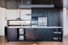 Modern home with Kitchen, Wood Cabinet, Pendant Lighting, Range Hood, Recessed Lighting, Undermount Sink, Wall Oven, Granite Counter, Beverage Center, Medium Hardwood Floor, and Refrigerator. A granite island countertop and black American oak cabinetry are a winning combination for the utilitarian kitchen. The sleek kitchen pendant lights are Matric-P4's from Lightnet. Photo 5 of Martha