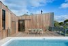Modern home with Outdoor, Large Pools, Tubs, Shower, Large Patio, Porch, Deck, Wood Patio, Porch, Deck, Swimming Pools, Tubs, Shower, Back Yard, Trees, and Metal Fences, Wall. To reduce the home's environmental footprint, OLA installed rain water collection tanks and solar panels, which the house relies upon for water and electricity. White tile and tan travertine pool pavers mimic the color palette of the nearby beach. Photo 7 of Martha
