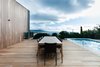 Modern home with Outdoor, Large Pools, Tubs, Shower, Swimming Pools, Tubs, Shower, Large Patio, Porch, Deck, Wood Patio, Porch, Deck, Trees, Back Yard, and Metal Fences, Wall. A Mood Outdoor Table by Studio Segers for Tribù is surrounded by Terra Outdoor Chairs by Bram Bollen, also for Tribù. They rest atop silvertop ash hardwood decking. Photo 8 of Martha