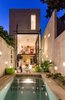 Modern home with Outdoor, Back Yard, Shrubs, Small Pools, Tubs, Shower, and Small Patio, Porch, Deck. The back of the home glows at night as the giant, two-story glass doors swing open to remove the barrier between inside and out. A polished concrete patio deck and pool, along with a simple block perimeter wall, make smart use of available materials. The pool acts as a passive conditioning tool, cooling air before it enters the house. The block wall is positioned 31 inches from the house, creating a gap or "air chimney" that allows air to circulate up and away from the home, while simultaneously letting light filter down. Photo of A Sustainable Mexican Retreat Made of Raw, Readily Available Materials
