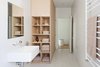 Modern home with Storage Room, Wall Mount Sink, Ceramic Tile Wall, Ceramic Tile Floor, and Shelves Storage Type. To stay within the budget, the designers decided to forgo natural stone in the bathrooms in lieu of simple vitrified tile. The bathroom isn't without its luxuries, however, as evidenced by the heated towel rail from Hydrotherm. Photo 5 of Seclusion