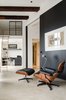 Modern home with Living Room, Concrete Floor, Recliner, Chair, Recessed Lighting, Ottomans, Floor Lighting, and Desk. This open-concept Amsterdam loft features soaring 15-foot ceilings, an Eames lounge chair and ottoman, and a Jielde light. Throughout the home, Standard Studio architects Wouter Slot and Jurjen van Hulzen favored raw materials, including concrete, oiled oak, and hot-rolled steel, all of which complemented the original space's industrial feel. Tucked smartly underneath the loft, a compact home office features functional built-in shelving and an Eames DSR chair. Photo of Bloemgracht